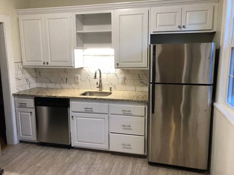Kitchen with white cabinets and stainless steel appliances in the condo on Robin Rd in West Hartford.