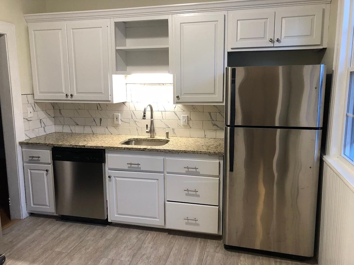 Kitchen with white cabinets and stainless steel appliances in the condo on Robin Rd in West Hartford.